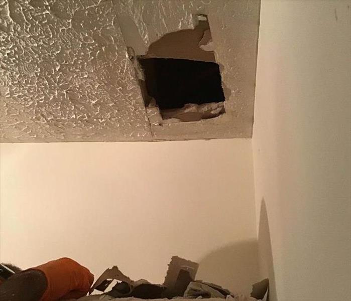 ceiling with small hole due to water damage in roof