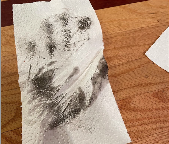 Paper towel with a soot handprint. 