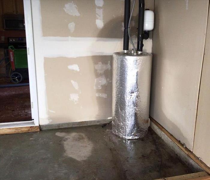 Water soaked concrete floor in a garage from a leaking hot water heater
